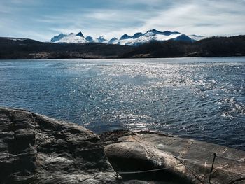 Scenic view of lake by mountains against sky