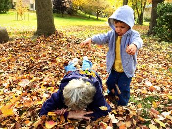 Full length of cute boy with dog in autumn