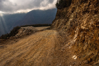 Mountain off road trail with dramatic cloudy sky at day