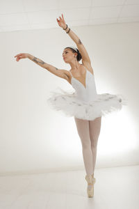 Ballet dancer on pointe with tattooed arms