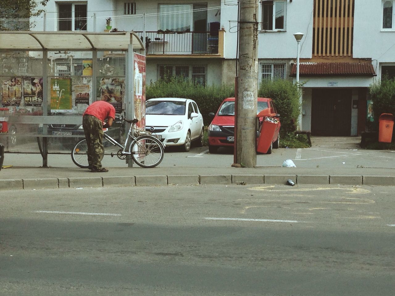 building exterior, land vehicle, transportation, architecture, built structure, mode of transport, bicycle, street, city, car, road, parked, stationary, parking, building, city life, day, city street, outdoors, sidewalk