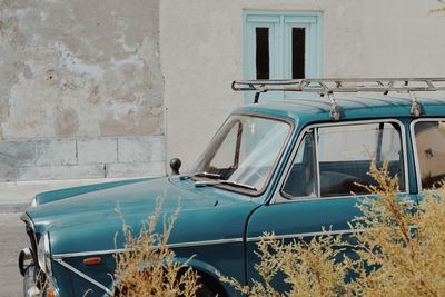 Abandoned car against building