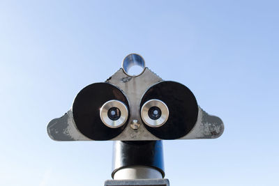 Close-up of coin operated binoculars against sky