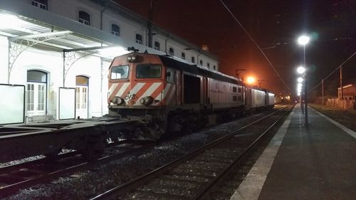 Train on railroad station platform at night