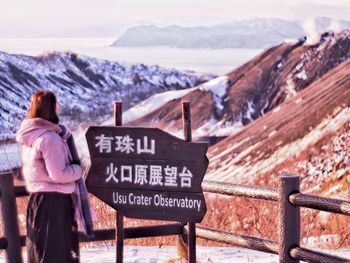 Rear view of person on snowcapped mountains during winter