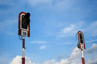 Low angle view of road signals against blue sky