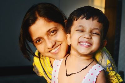 Portrait of smiling mother and daughter at home