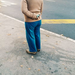 Low section of woman standing on road
