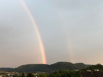 Scenic view of rainbow over mountains against sky
