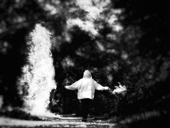 Rear view of girl standing in water