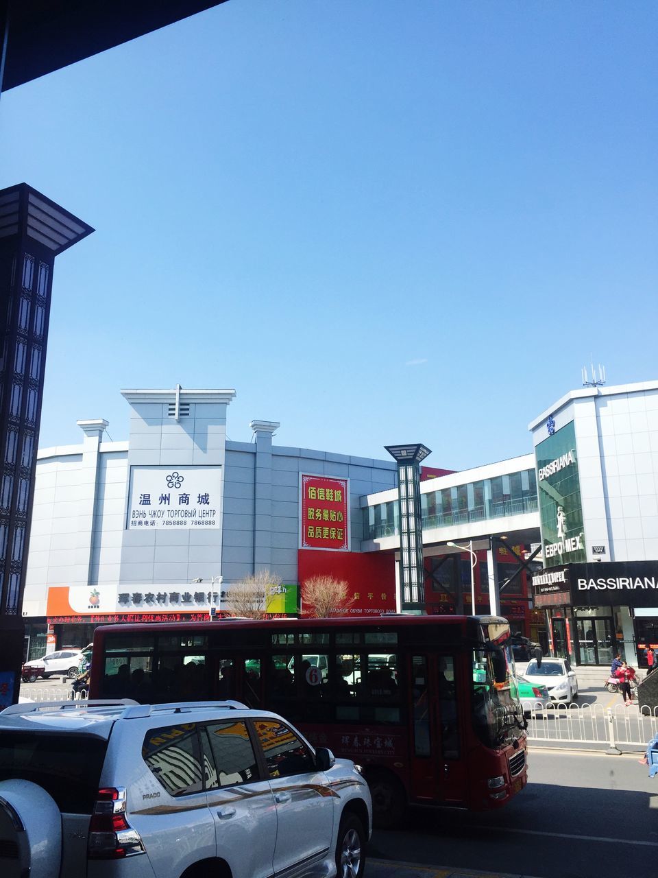 transportation, clear sky, architecture, land vehicle, built structure, building exterior, car, mode of transport, street, city, road, copy space, city life, blue, communication, text, western script, road sign, incidental people, day