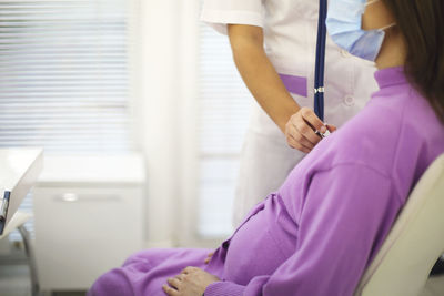 Midsection of doctor examining patient in hospital