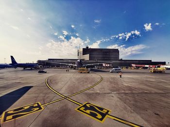 Airplane on airport runway against sky