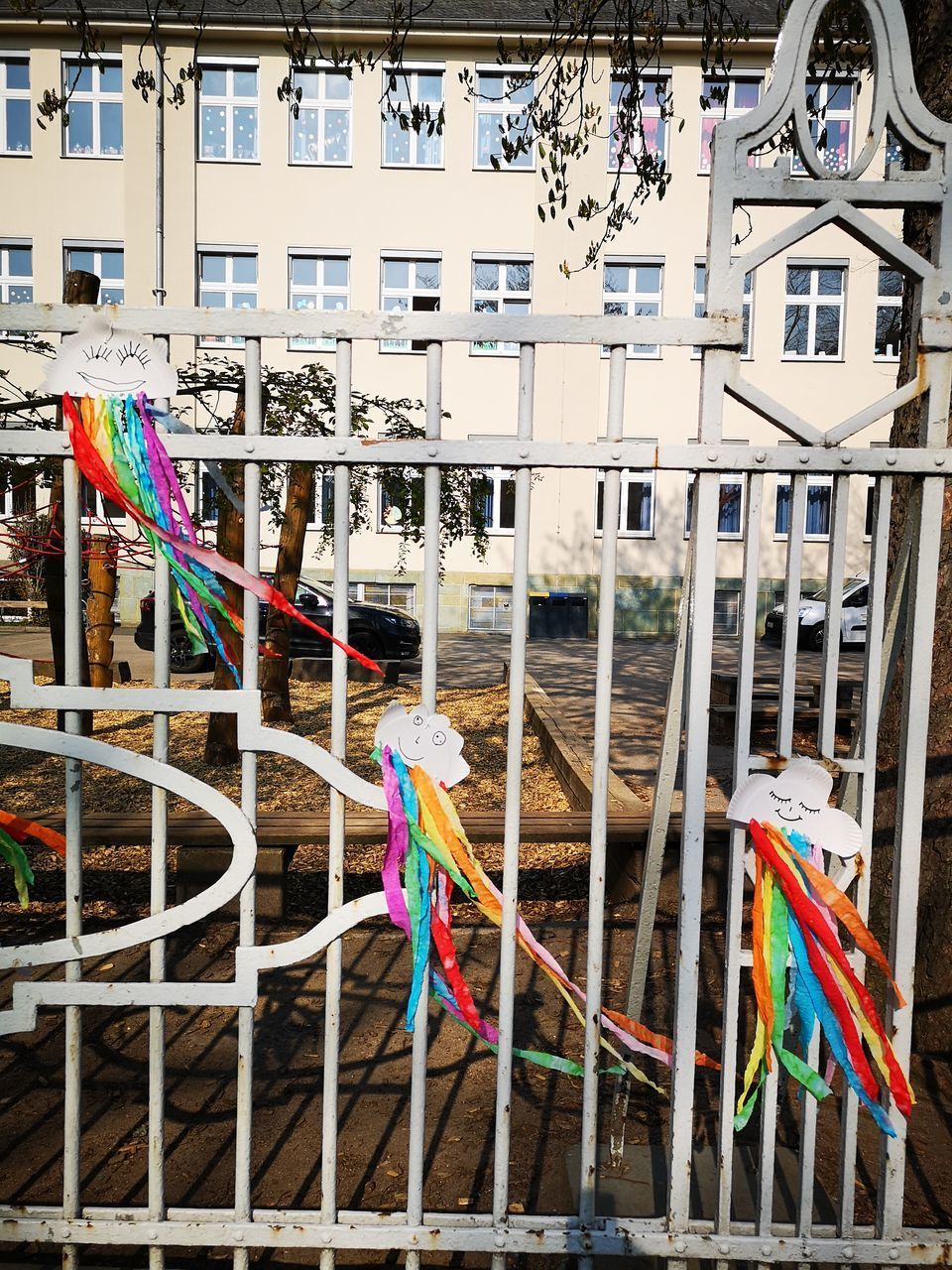 CLOSE-UP OF MULTI COLORED FLAGS HANGING ON RAILING AGAINST BUILDING