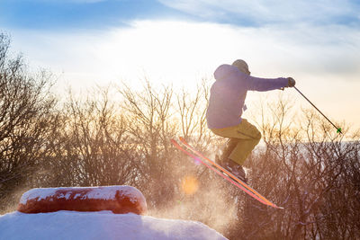 Man on snow covered land against sky