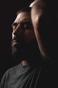 Close-up portrait of man against black background
