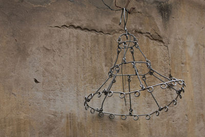 Close-up of chain hanging against wall