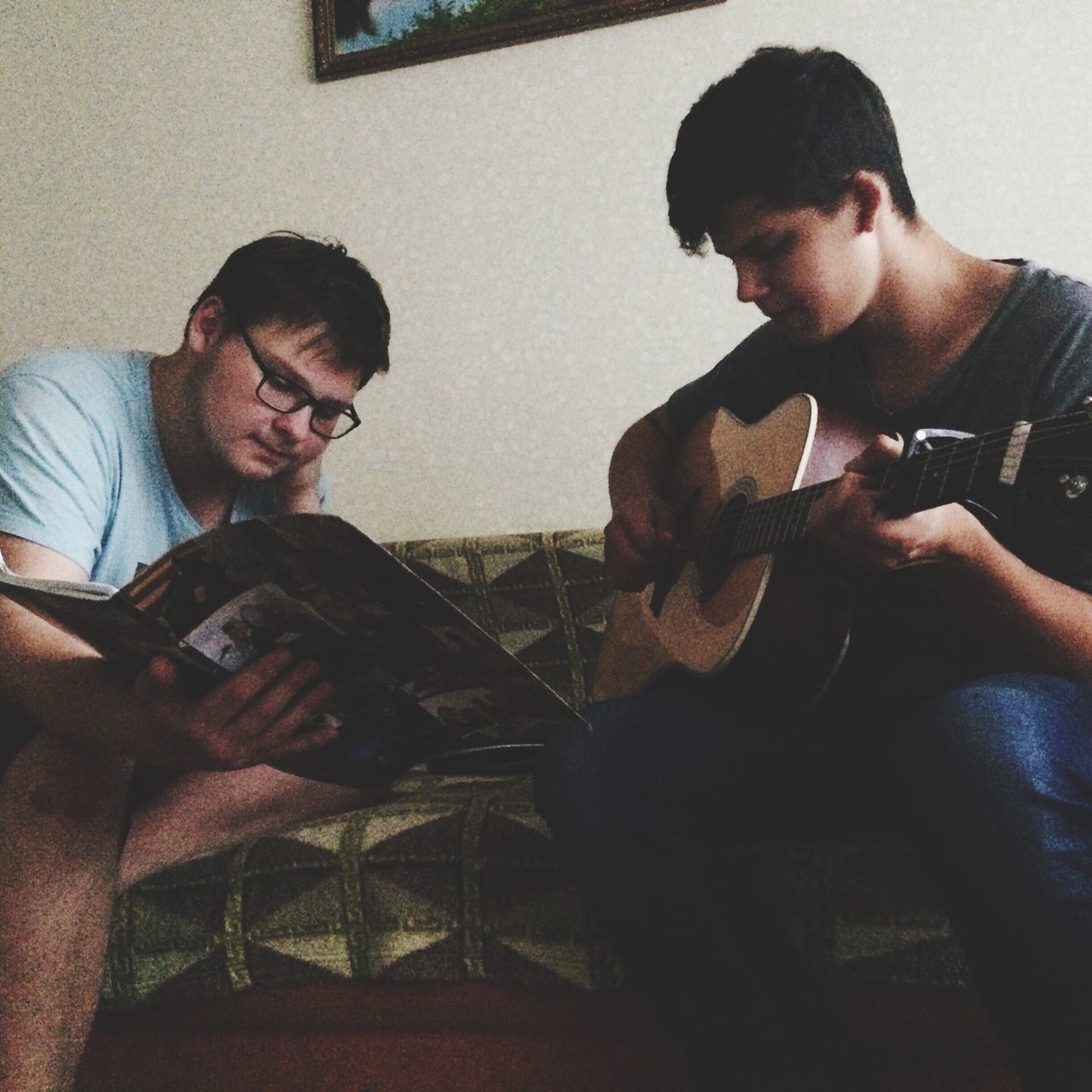 two people, real people, eyeglasses, indoors, young men, young adult, leisure activity, playing, glasses, home interior, lifestyles, sitting, togetherness, weapon, men, day, people