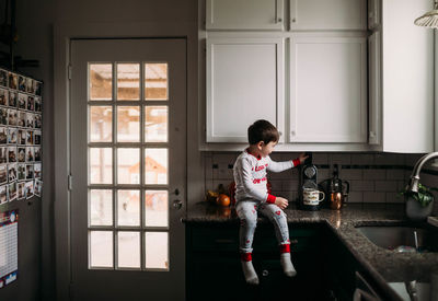 Boy standing by window at home