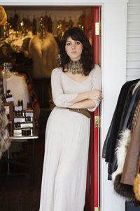 Portrait of woman standing at boutique entrance