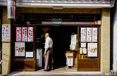 Rear view of man standing at store