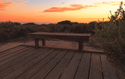 Boardwalk against sky during sunset