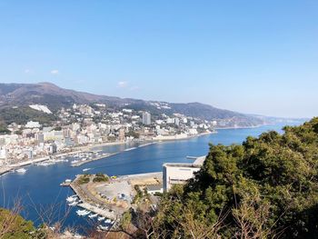 High angle view of town by sea against clear sky