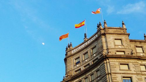 Low angle view of flag against blue sky