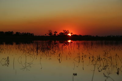 Scenic view of lake against romantic sky at sunset