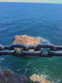 Close-up of chain against sea