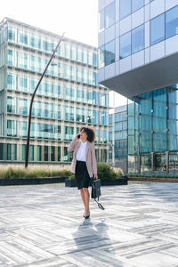 Full length of young woman standing in city