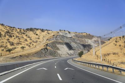 Road amidst mountains against clear sky