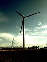 Windmill on field against sky