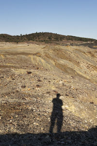 Shadow of people on land against sky