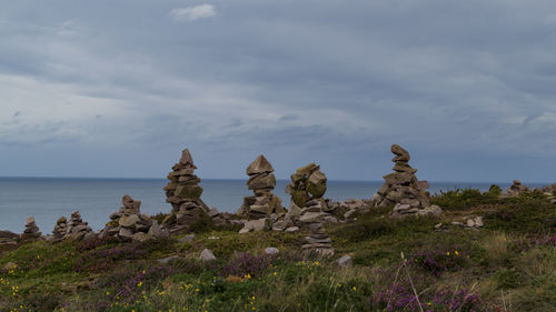 Rock formation on beach against sky