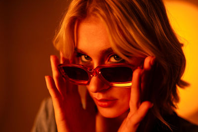 A woman wearing sunglasses is covering her face with her hands