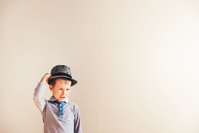 Portrait of boy standing against wall