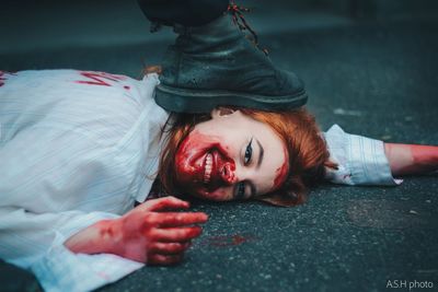 Portrait of young woman lying down on sofa during halloween