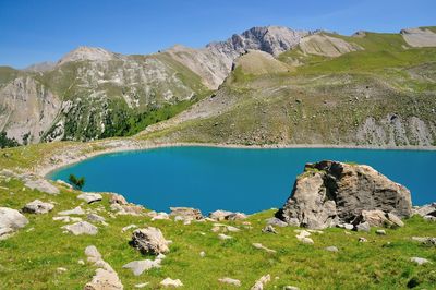 Scenic view of lake and mountains against blue sky