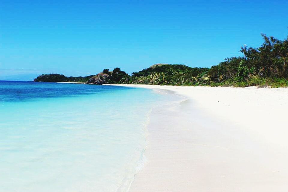 SCENIC VIEW OF BEACH AGAINST BLUE SKY