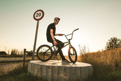 Side view of man riding bicycle on road