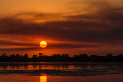 Scenic view of lake against romantic sky at sunset