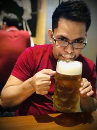 Portrait of man with drink sitting on table