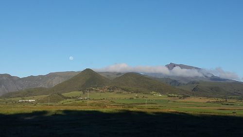 Scenic view of landscape and mountains against clear blue sky