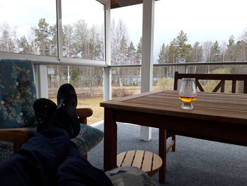 Rear view of man sitting by glass window