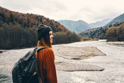 Woman standing on beach against mountain range