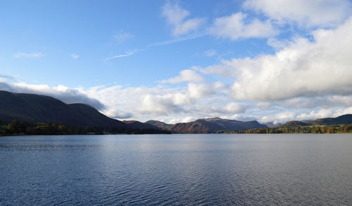 Lake with mountain range against cloudy sky