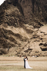 People standing on rock in desert