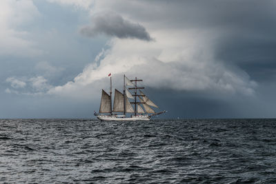 Sailboat sailing on sea against sky