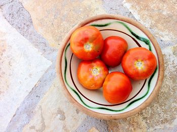 Directly above view of tomatoes in bowl on floor